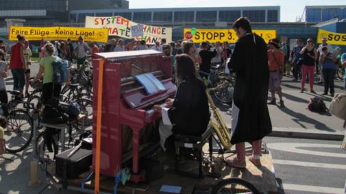 Open Piano for Refugees bei der Kundgebung Open Piano for Refugees bei der Kundgebung, im Hintergrund einige der Transparente