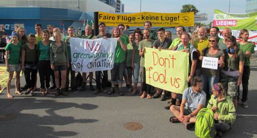 Alle Teilnehmer mit grünen Gewand mit Transparenten gegen Greenwashing Alle Teilnehmer mit grünen Gewand mit Transparenten gegen Greenwashing